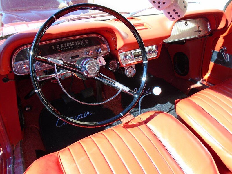 Classic car's orange interior and steering wheel.