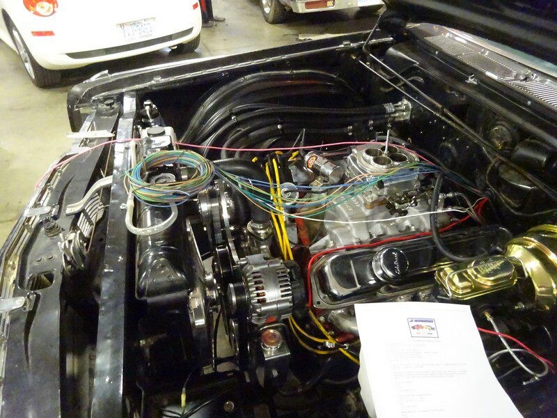 Car engine bay with wiring and components.