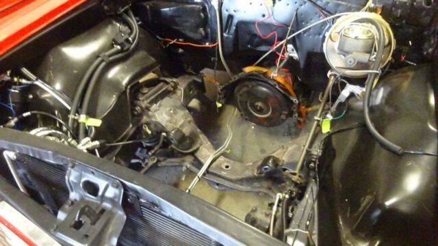 Red classic car engine bay restoration.