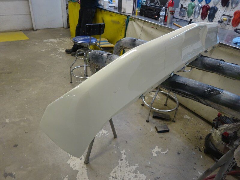 Painted car body part on stand.