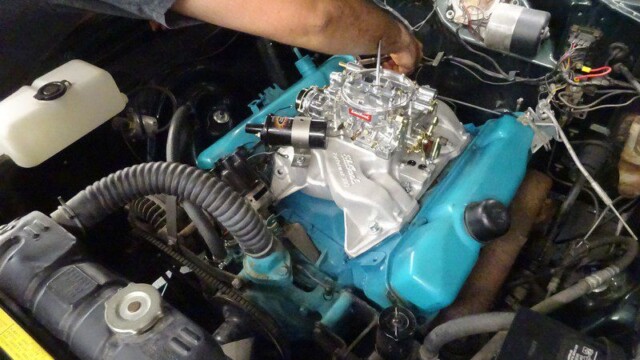 Mechanic working on a teal engine.