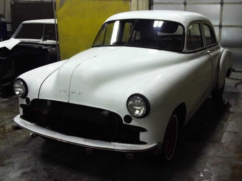White classic car in garage restoration.