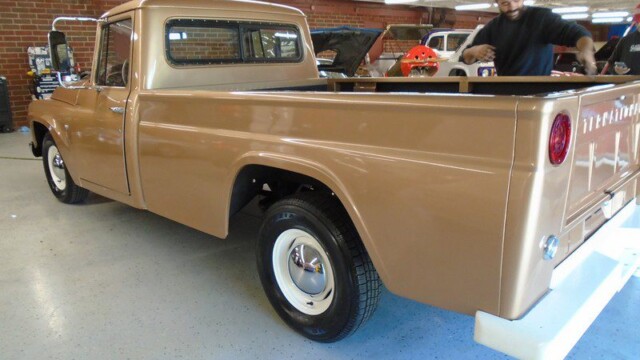 Beige vintage pickup truck in garage.