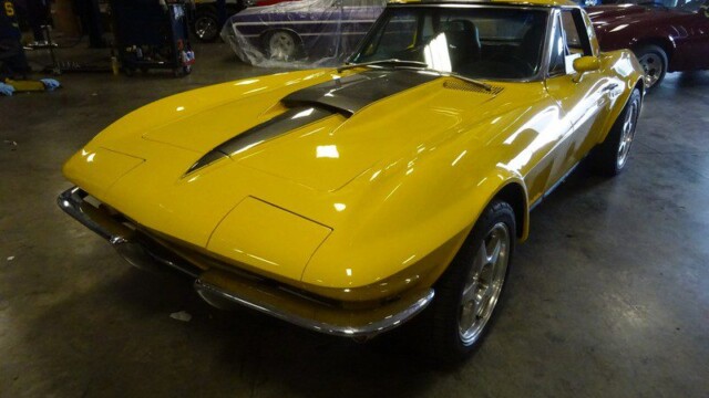 Yellow Corvette Stingray in garage.