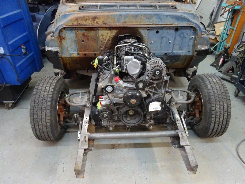 Classic car engine installation in progress.