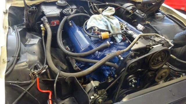 Classic car engine bay, blue valve covers.