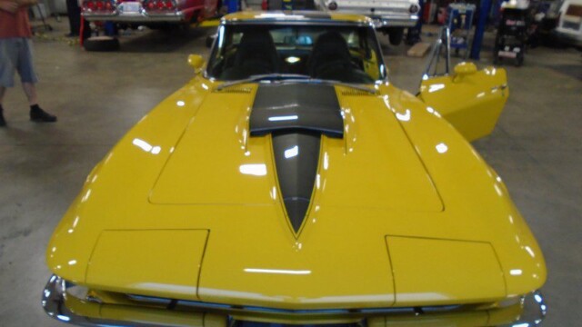 Yellow Corvette Stingray in garage.