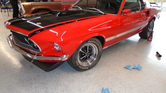 Red Ford Mustang Mach 1 in garage.