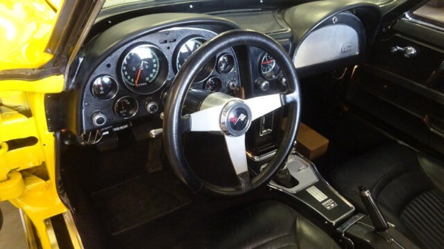 Yellow Corvette interior dashboard view.