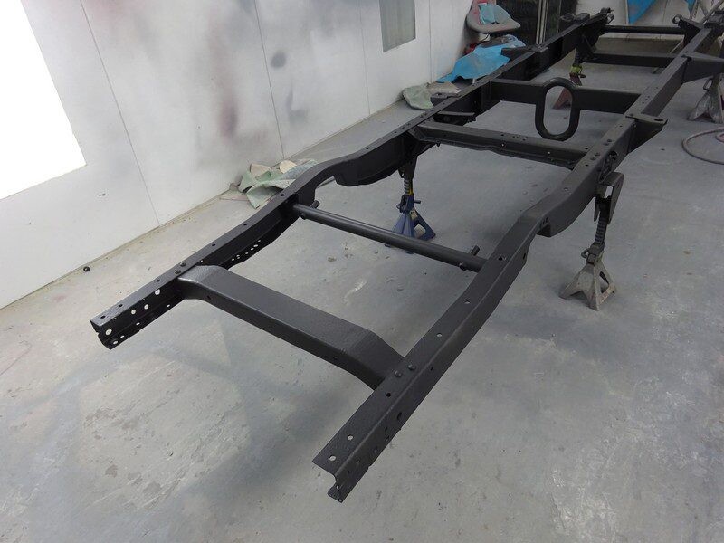 Black truck frame on jack stands.