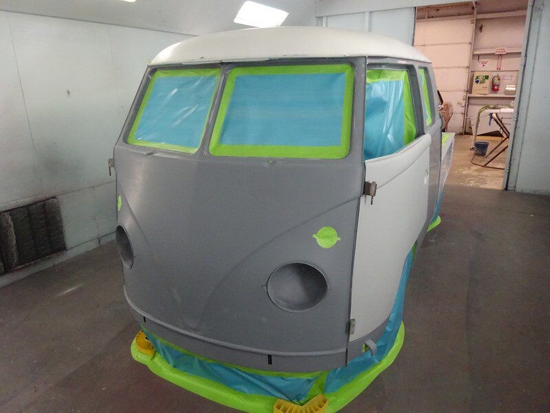 Gray Volkswagen bus in paint booth.