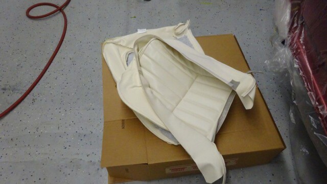 Cream car seat upholstery on cardboard.