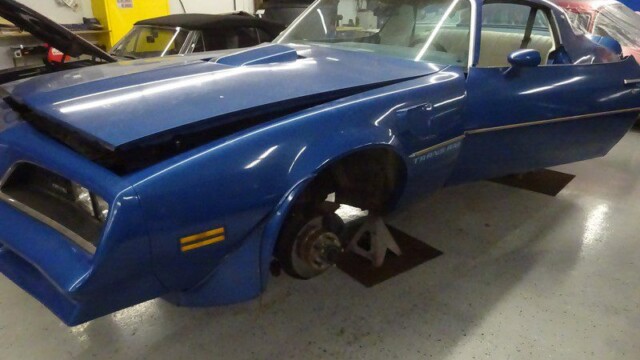 Blue Pontiac Trans Am under repair.