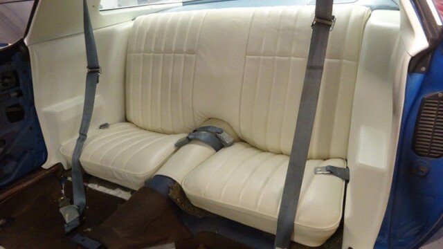 Off-white rear seats in a classic car.