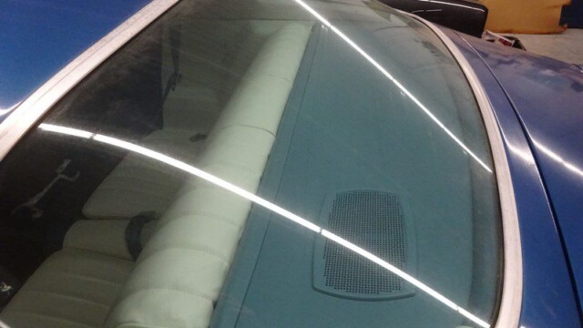 Rear windshield showing cream seat and speaker grille