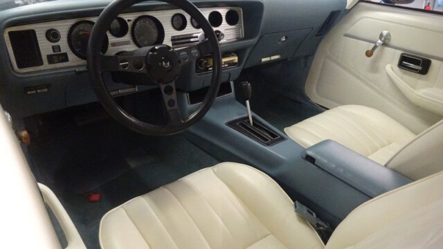 Here's an 8-word alt tag for the image: Classic Pontiac Trans Am interior, blue and white.