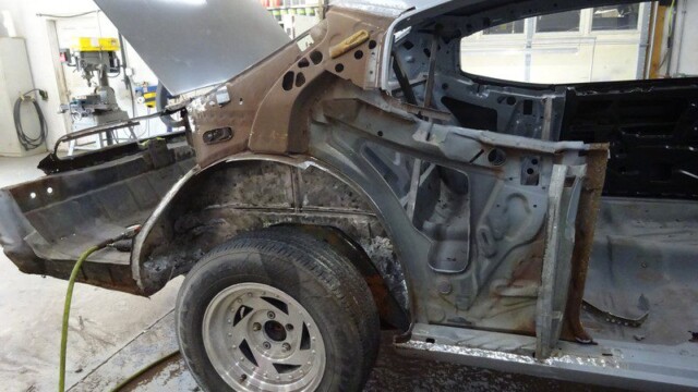 Car body undergoing restoration work.