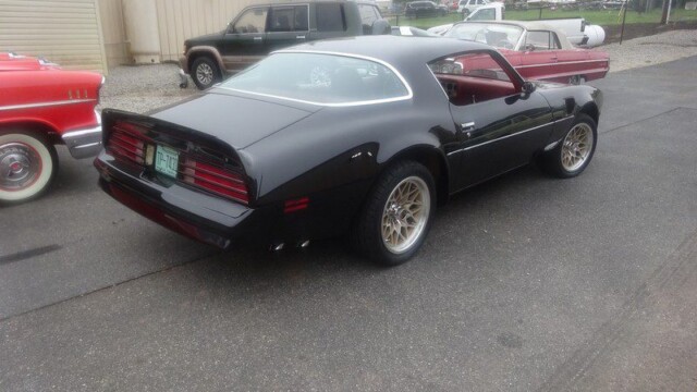 Black Pontiac Trans Am parked outdoors.