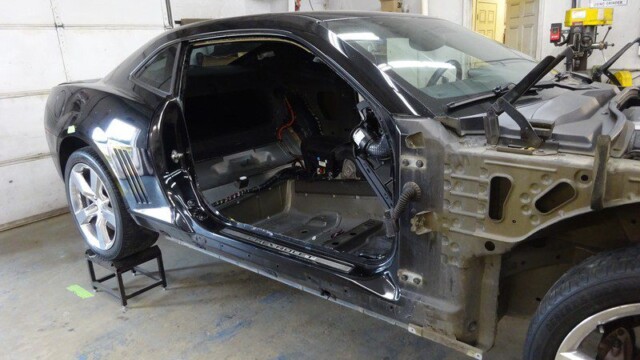 Damaged Camaro undergoing repairs.