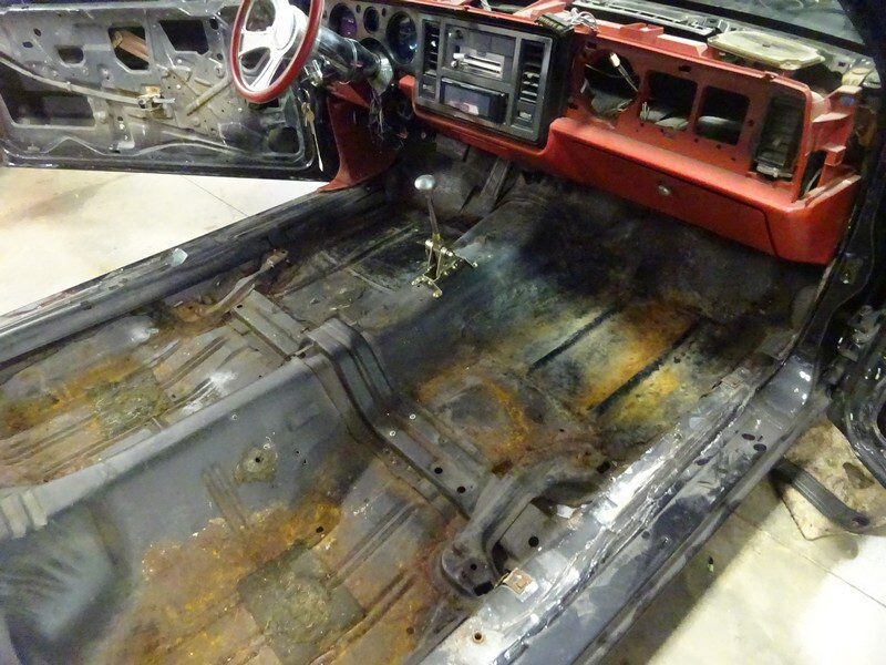 Rusty car interior floor needs repair.