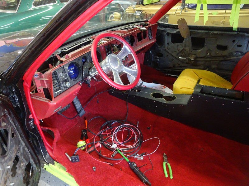 Car interior under construction, red carpet.