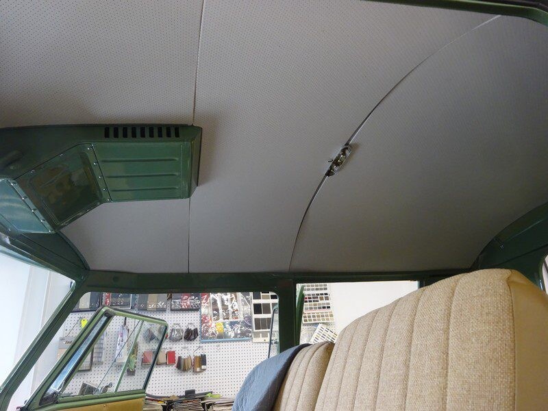 Here's an 8-word alt tag for the image: Vintage van's newly installed headliner and rear seats.