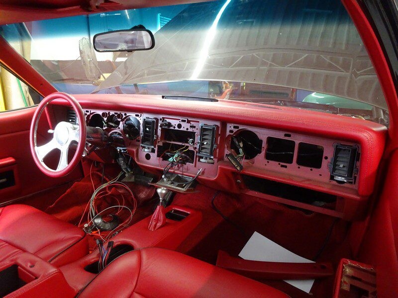 Red car interior under construction.