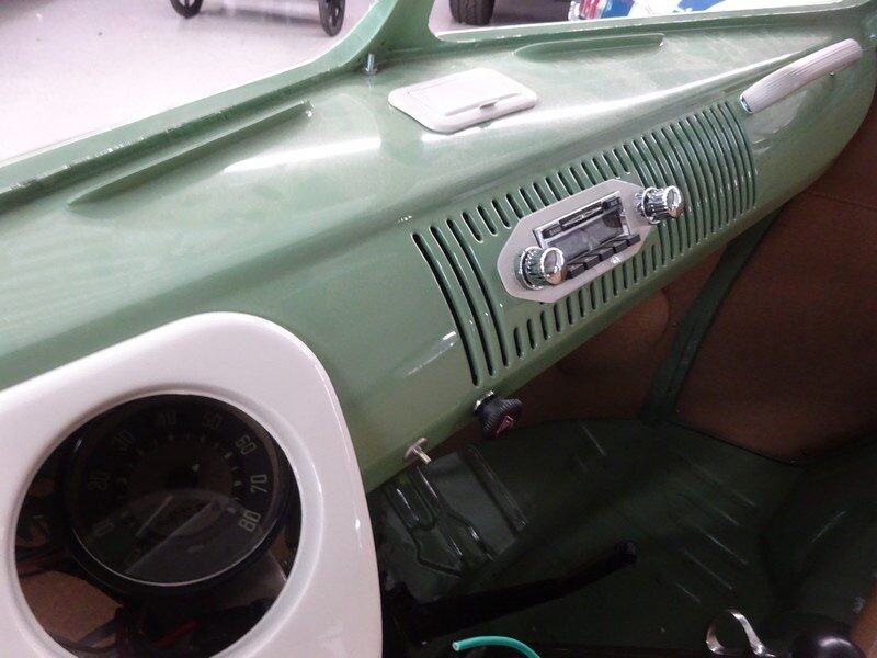 Vintage car dashboard with radio and speedometer.