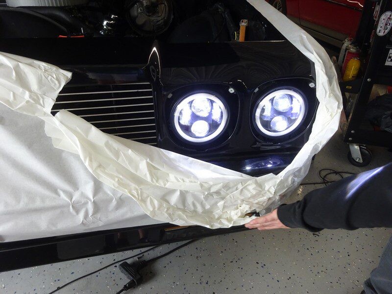 Black car's headlights partially covered.