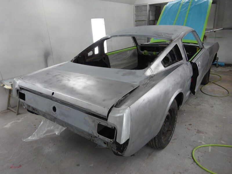 Primered classic Mustang in auto body shop.
