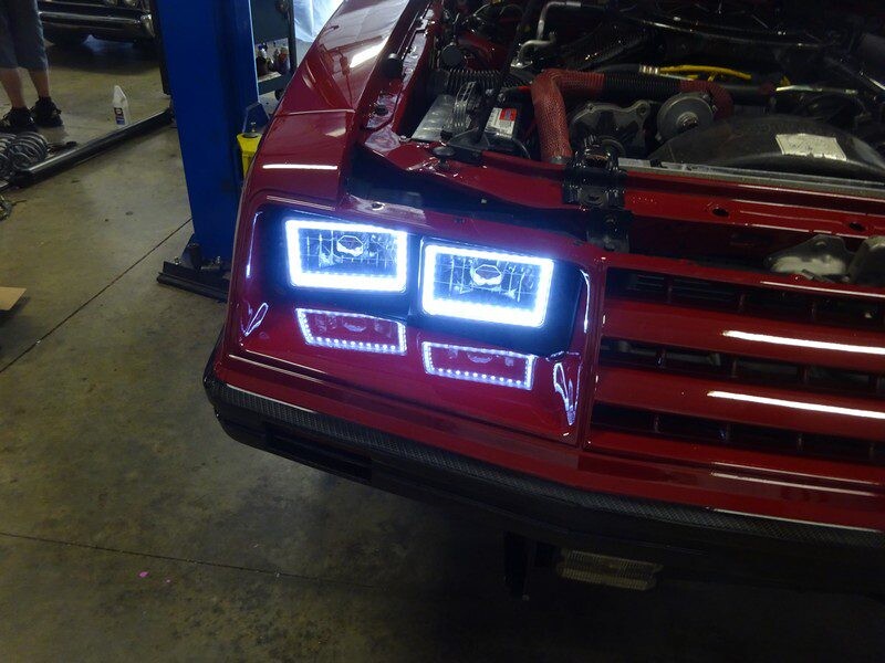 Red car's custom headlights glowing.