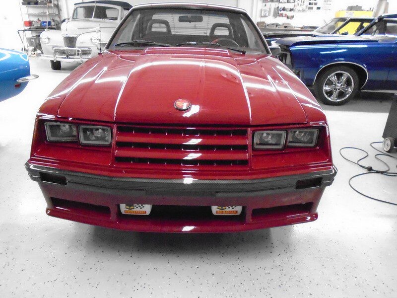 Red Ford Mustang in garage.