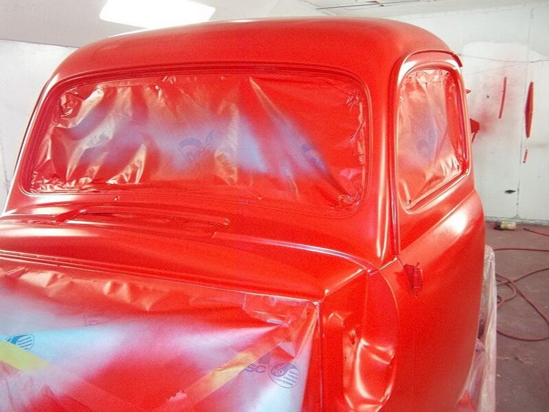 Red classic truck being painted.