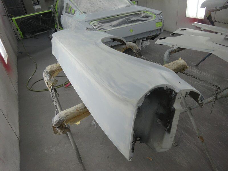 Primed car body panel in shop.
