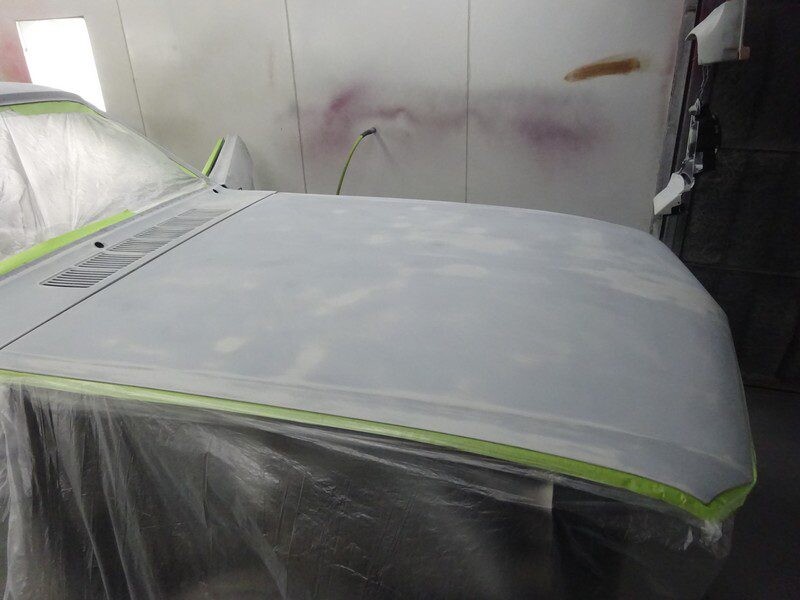 Car hood in primer, paint shop.