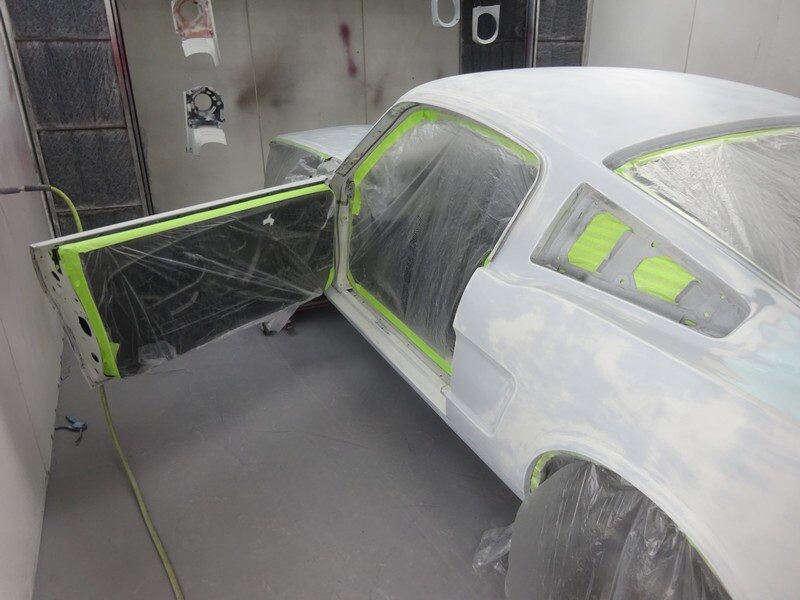 Primed classic Mustang in auto body shop.