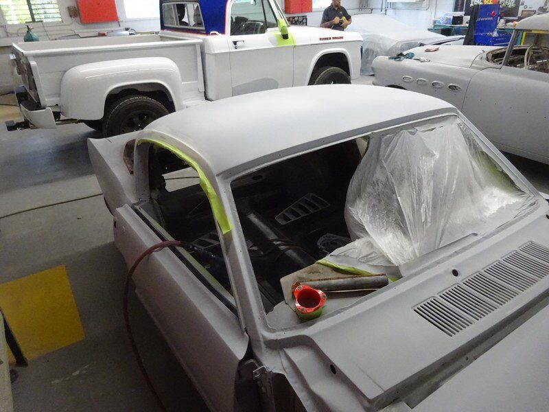 Primered muscle car body in progress.