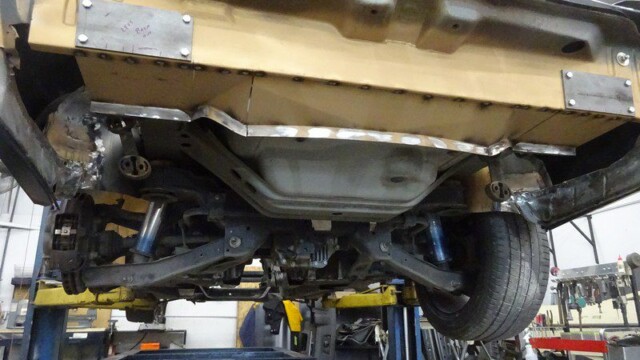 Car underside undergoing repair welding.