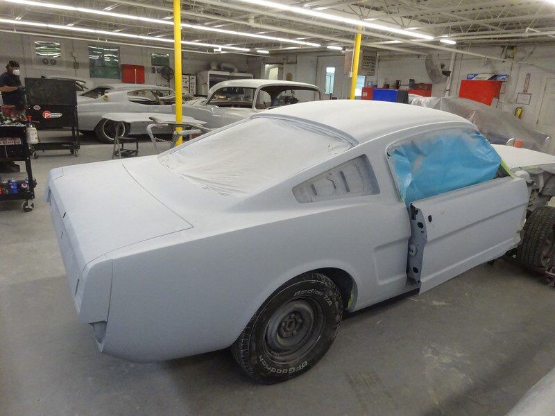 Primered classic Mustang in auto shop.