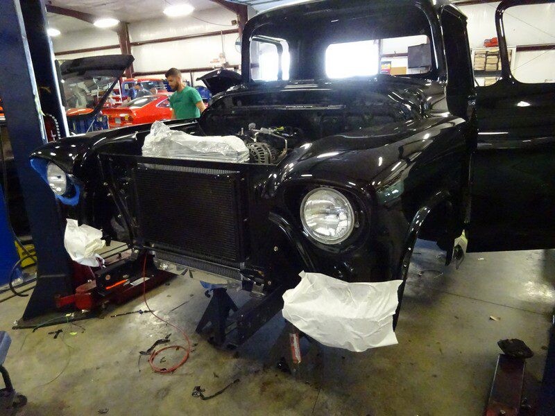 Black classic truck under repair.