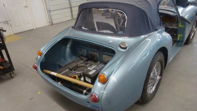 Light blue classic car trunk open.