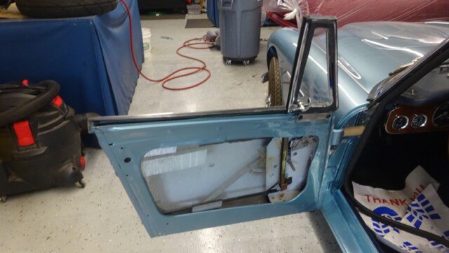 Light blue door with exposed inner mechanisms