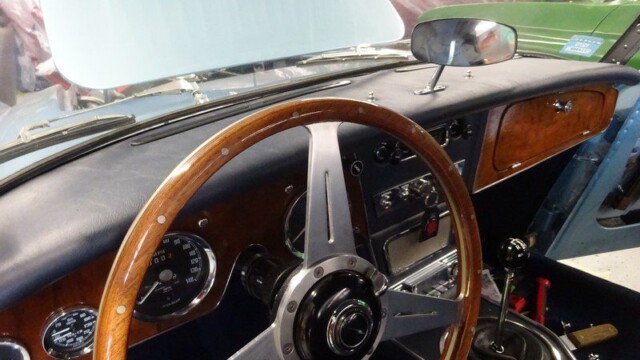 Classic car interior, wooden steering wheel.
