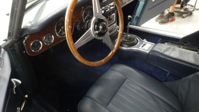 Classic car's interior, wooden steering wheel.