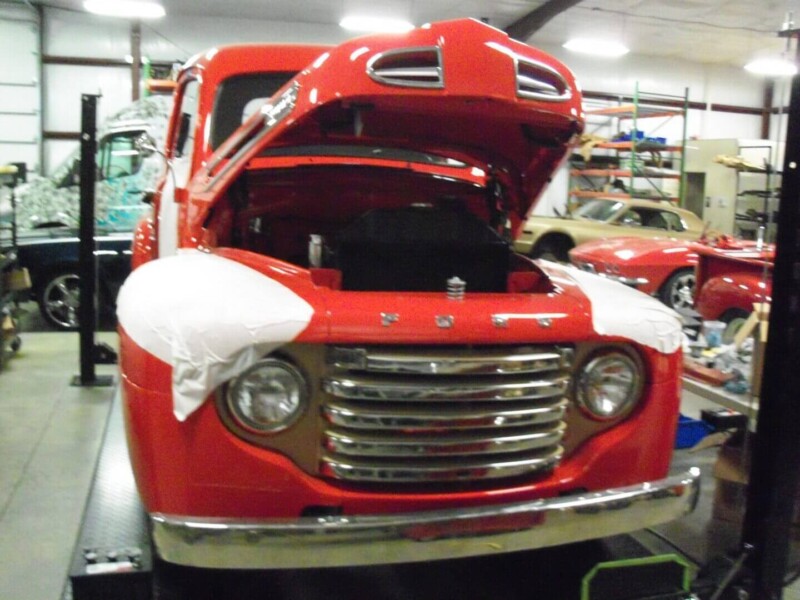 Red Ford pickup truck, hood open.