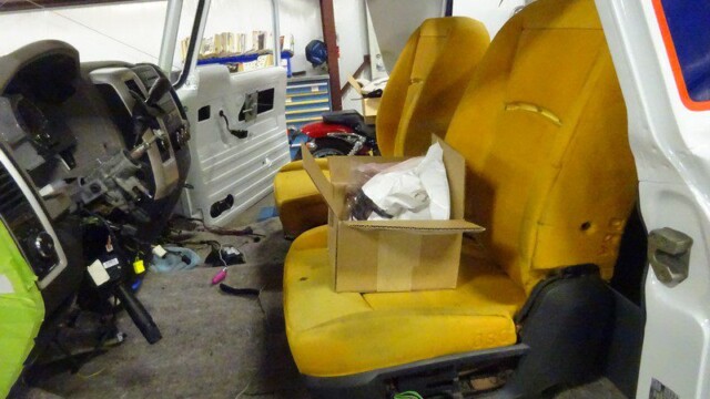 Truck interior under construction, yellow seats.