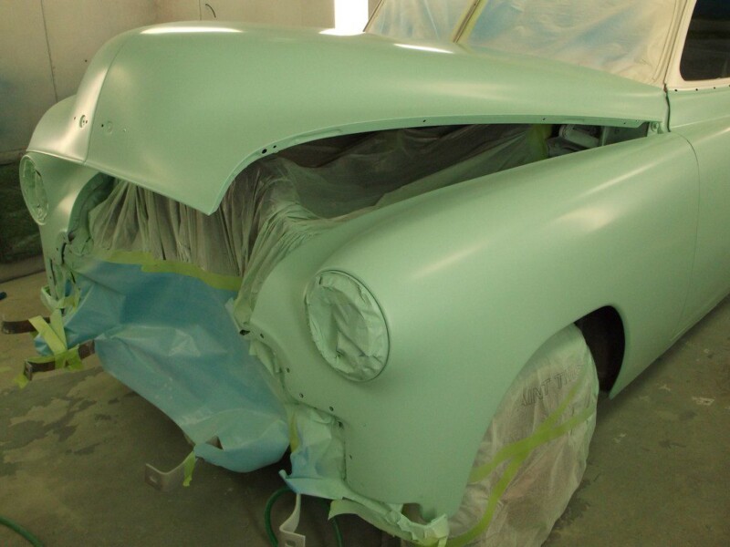 Light green classic car body in paint booth.