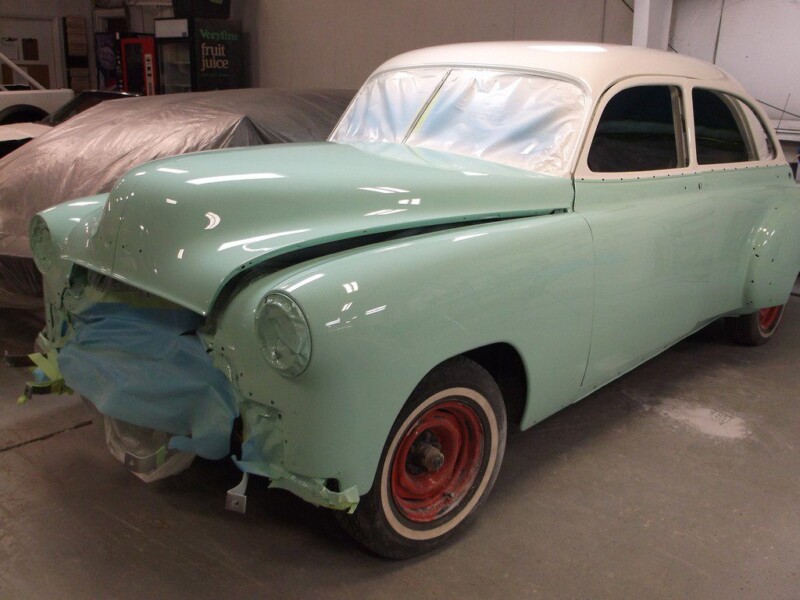 Light green vintage car in auto shop.