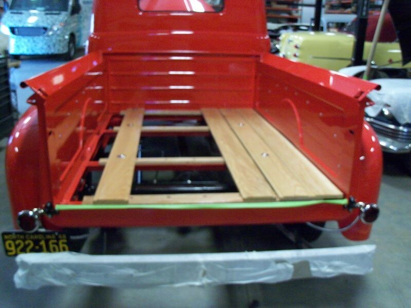 Red truck bed with wooden planks.