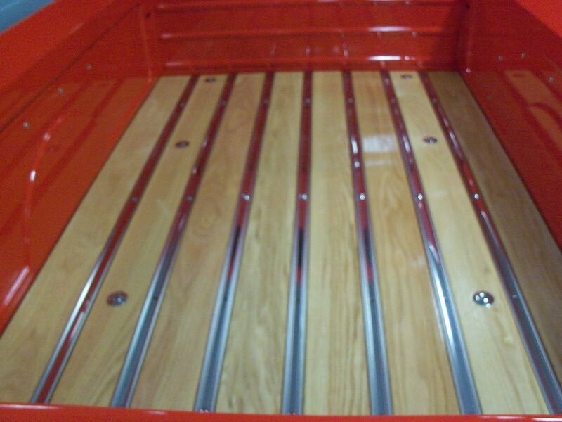 Red truck bed with wooden planks.